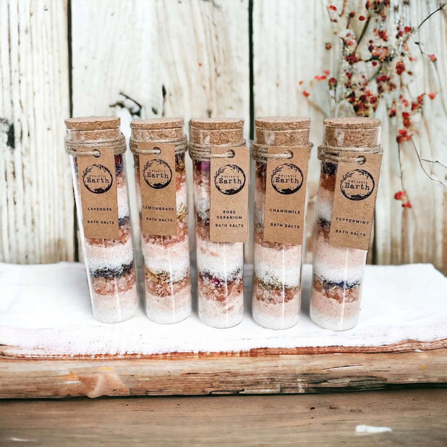 Five Holistic Earth Bath salt tubes lined up against a bathroom background.