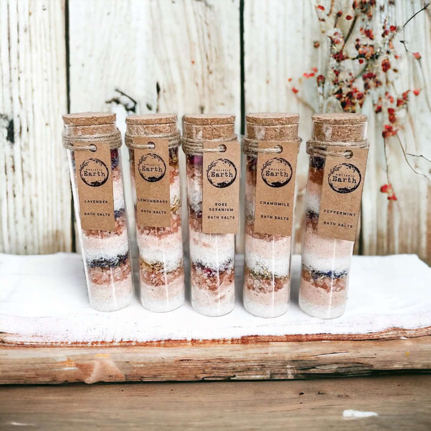 Five Holistic Earth Bath salt tubes lined up against a bathroom background.