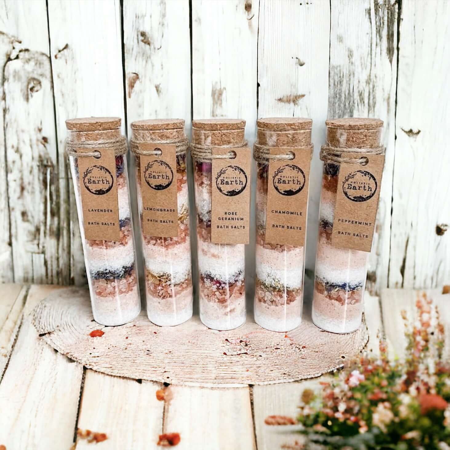 Five Holistic Earth Bath salt tubes lined up against a bathroom background.